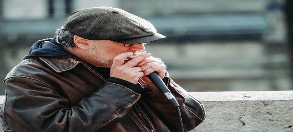 Hombre tocando la armónica en una plaza